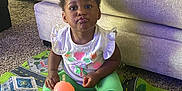 Kaylani joined the competition — help win amazing prizes! toddler, child, indoor, sippy_cup, play_mat, carpet, couch, white_shirt, green_pants, pouting, funny_face, sitting, toy, floor, home, cute, expression, footwear, hair_bow, person