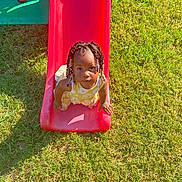 Kaylani joined the competition — help win amazing prizes! beaded_hair, child, curious, cute, daylight, fun, grass, green_grass, outdoor, park, play, playground, shoes, slide, summer, sunlight, toddler, toy, yellow_dress, young_child
