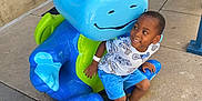Reese joined the competition — help win amazing prizes! blue, boy, casual_clothing, child, concrete, daylight, dinosaur, footwear, green, happy, outdoor, person, playful, shirt, shorts, sidewalk, smile, statue, toy, urban