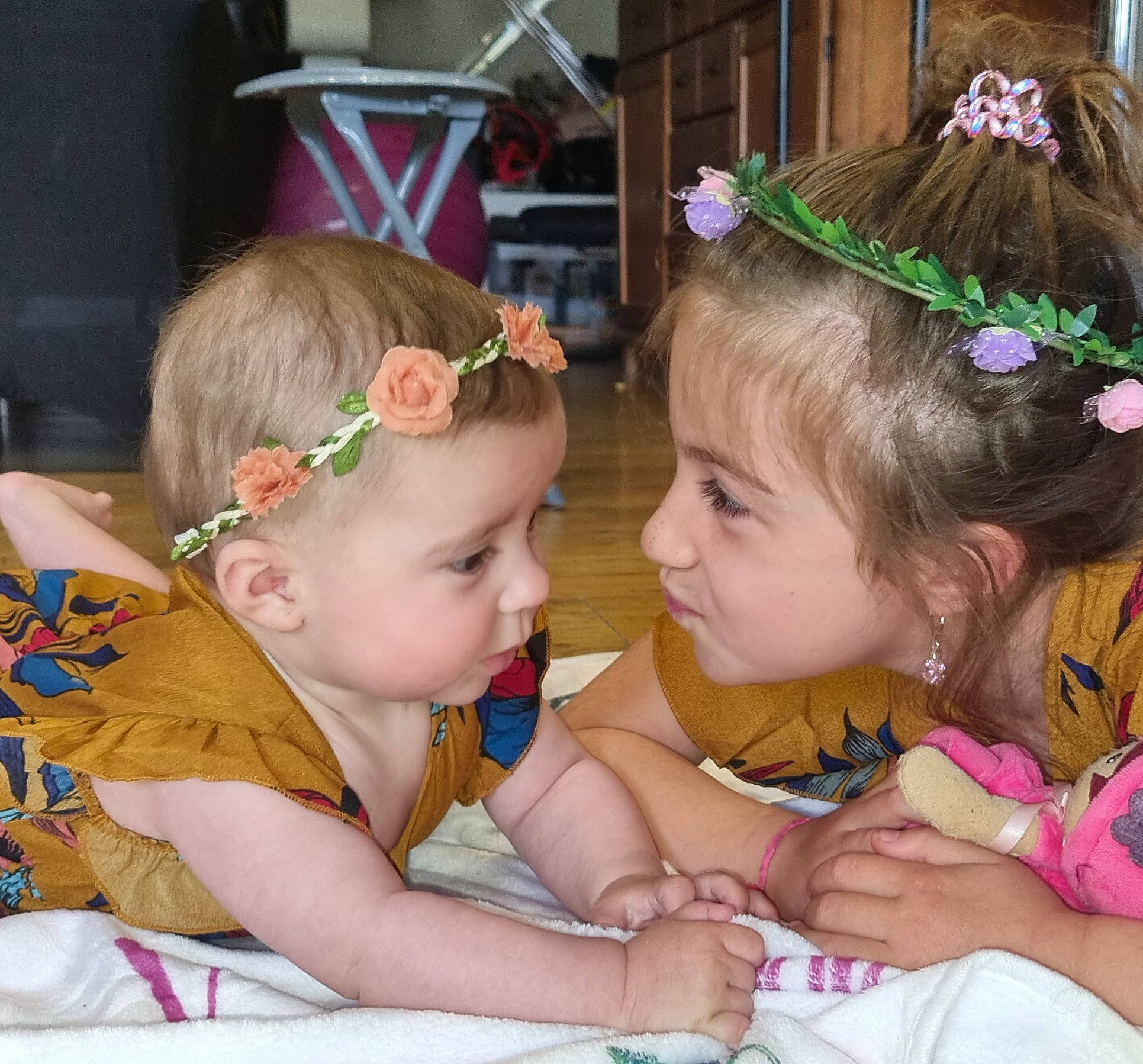 Andréa a rejoint le concours — aidez-le/la à gagner de superbes lots ! baby_toddler_clothing, chair, cheek, flower, fun, hair, hair_accessory, hairstyle, happy, headband, headgear, headpiece, iris, jewellery, lei, person, pink, plant, sharing, skin