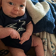 Zayden joined the competition — help win amazing prizes! baby, infant, onesie, socks, blanket, blue, white, pattern, face, hands, legs, skin, person, indoor, closeup, expression, cute, soft, cozy, resting
