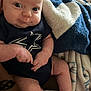 baby, infant, onesie, socks, blanket, blue, white, pattern, face, hands, legs, skin, person, indoor, closeup, expression, cute, soft, cozy, resting