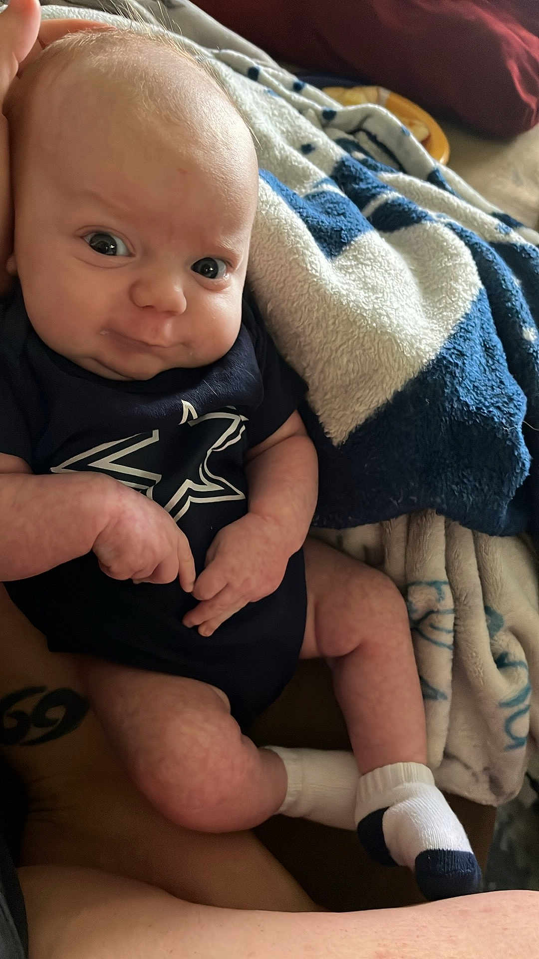 Zayden joined the competition — help win amazing prizes! baby, infant, onesie, socks, blanket, blue, white, pattern, face, hands, legs, skin, person, indoor, closeup, expression, cute, soft, cozy, resting