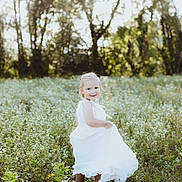 Ambre participe au concours pour gagner de l'argent avec cette photo : child, girl, white_dress, meadow, wildflowers, nature, outdoor, sunlight, trees, smile, happy, toddler, grass, summer, portrait, playful, flower_field, greenery, childhood, sunny