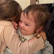 Emerson is registered to the contest to win money with this photo: child, baby, toddler, sibling, hug, highchair, bib, food, mealtime, smile, embrace, hair, hand, sleeve, clothing, indoor, wall, portrait, happy, seat