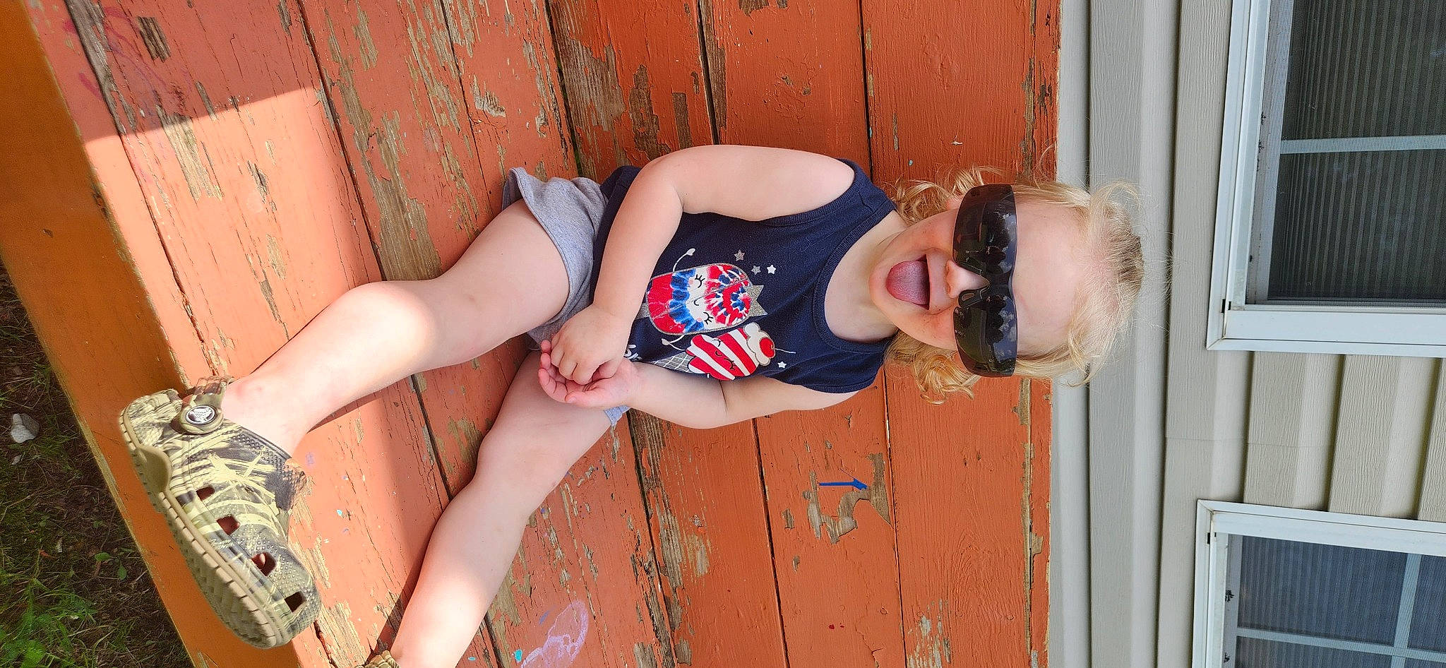 Layla is registered to the contest to win money with this photo: door, elbow, eyewear, finger, foot, hand, human_body, human_leg, joint, knee, leg, muscle, orange, person, shoulder, sunglasses, thigh, trunk, waist, wood