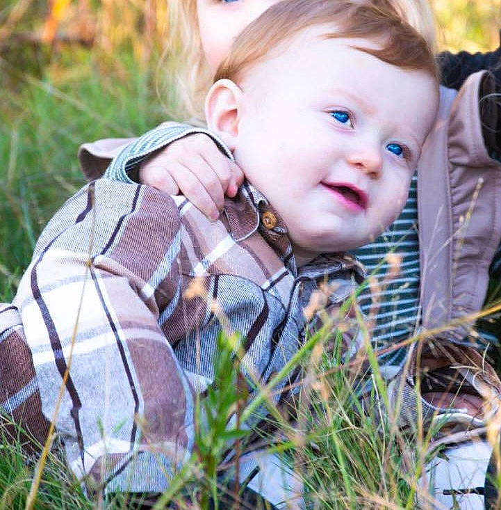 Levi is registered to the contest to win money with this photo: baby, baby_toddler_clothing, child, eye, fawn, fun, grass, grass_family, happy, iris, pattern, people_in_nature, person, plaid, plant, sitting, skin, smile, toddler, tree