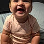 Delilah is registered to the contest to win money with this photo: baby, child, smiling, indoor, bed, clothing, pink_outfit, happy, cute, infant, portrait, sitting, chubby_arms, face, young, person, one_person, home, toddler, joyful