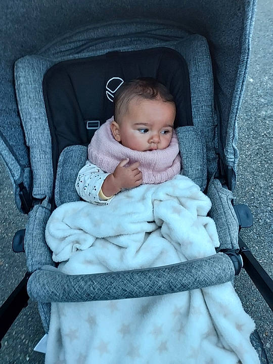 Naya participe au concours pour gagner de l'argent avec cette photo : arm, baby, baby_carriage, baby_products, baby_toddler_clothing, chair, cheek, child, comfort, eye, grey, hand, iris, person, product, sitting, skin, smile, style, toddler