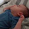baby, sleeping, blue_clothing, bed, pillow, blanket, infant, peaceful, resting, indoors, child, person, portrait, cozy, relaxing, cute, newborn, soft, young, comfort