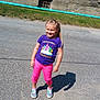 Davina is registered to the contest to win money with this photo: child, girl, smiling, purple_shirt, pink_pants, sneakers, shadow, street, sidewalk, grass, wall, window, pipe, sunny, outdoor, standing, casual_clothing, happy, daytime, preschool_princess
