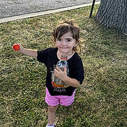 Delilah joined the competition — help win amazing prizes! child, girl, grass, tree, sidewalk, bottle, cap, black_tshirt, pink_shorts, sneakers, outdoor, playful, cute, young, casual, daylight, expression, holding, standing, nature