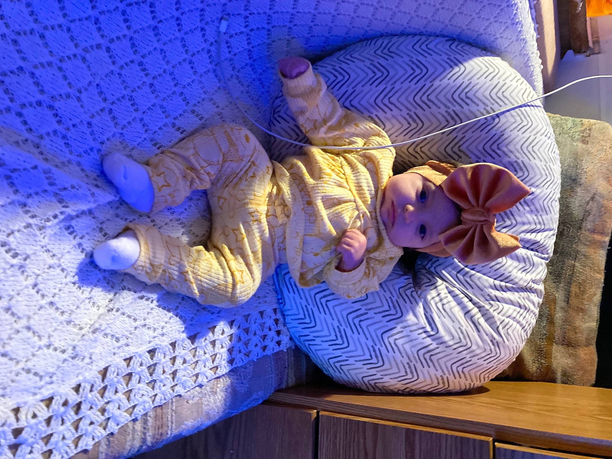 Amirah is registered to the contest to win money with this photo: blue, comfort, electric_blue, flooring, hardwood, hat, headwear, human_leg, linens, magenta, nap, person, personal_protective_equipment, purple, room, sitting, textile, violet, wood, wood_flooring