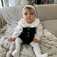 Kiara a rejoint le concours — aidez-le/la à gagner de superbes lots ! baby, child, infant, girl, sitting, blanket, couch, headband, white_tights, romper, white_blouse, indoor, portrait, face, blue_eyes, soft_lighting, furniture, home, cute, young