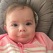 Romy participe au concours pour gagner de l'argent avec cette photo : baby, infant, face, child, pink_jacket, adidas, clothing, cushion, seated, indoors, portrait, cute, young_child, apparel, jacket, expression, looking_at_camera, head_support, small_child, person