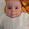 Romy participe au concours pour gagner de l'argent avec cette photo : baby, infant, face, eyes, sweater, knitwear, blanket, orange, brown, skin, head, cute, portrait, child, newborn, lying_down, indoors, young, expression, warm