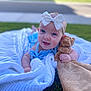 baby, blanket, blue_eyes, bow, child, clothing, cute, grass, happy, headband, infant, lying_down, nature, outdoor, person, portrait, smile, stuffed_animal, sunlight, toy