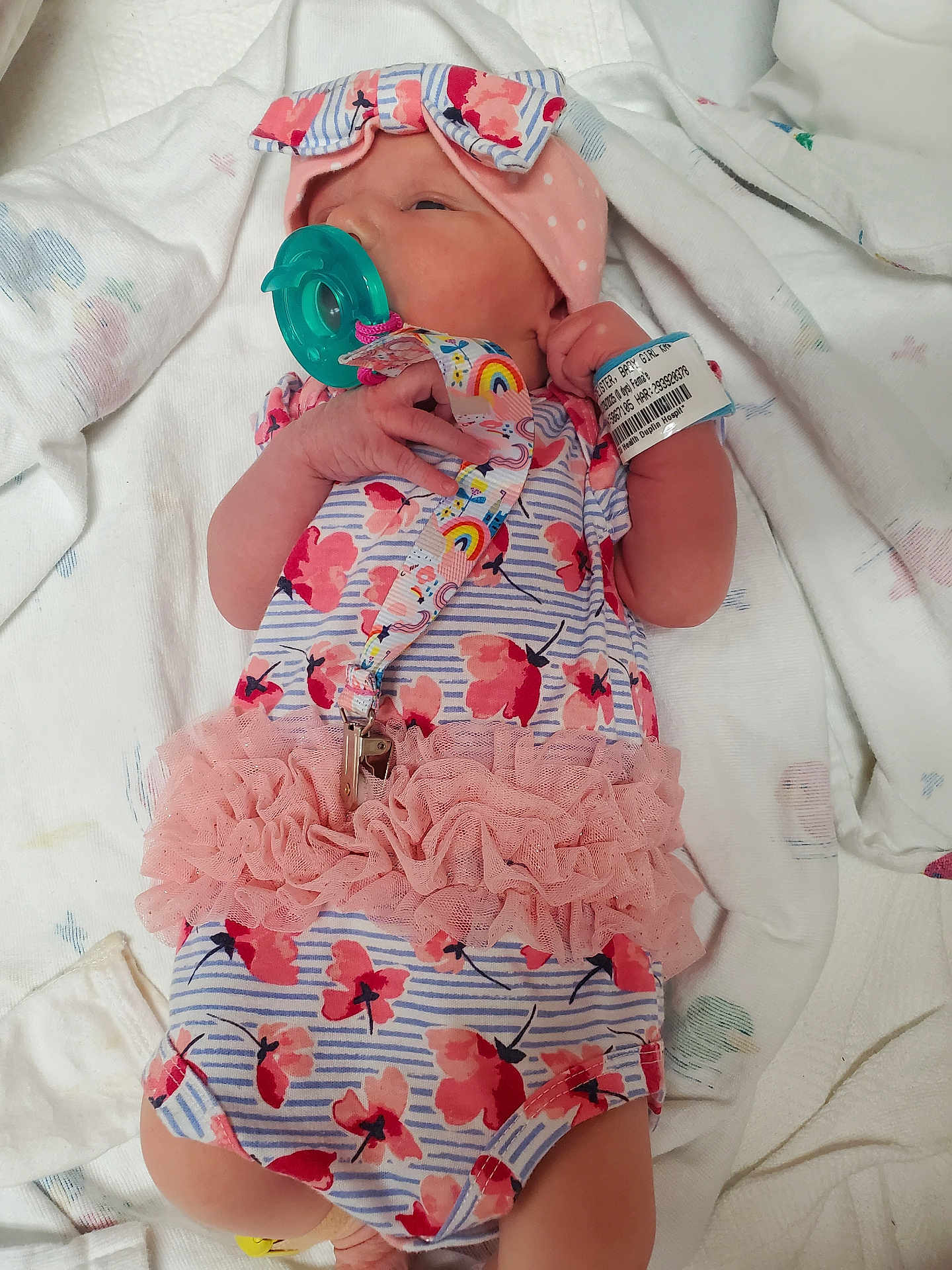 Avalynn joined the competition — help win amazing prizes! baby, newborn, infant, pacifier, onesie, headband, hospital_bracelet, blanket, pink, floral, tutu, sleeping, lying_down, cute, child, small_hand, soft, adorable, person, newborn_clothing