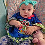 Avalynn joined the competition — help win amazing prizes! baby, blue_clothing, bow, child, colorful, comfort, cushion, cute, expression, face, hand, headband, indoor, infant, patterned_clothing, plush_toy, portrait, seated, soft_toy, young_child