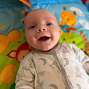 Elio a rejoint le concours — aidez-le/la à gagner de superbes lots ! animal_print, baby, child, clothing, colorful, cute, expression, face, happy, head, indoors, infant, joyful, lying_down, onesie, playmat, portrait, smile, soft_focus, young