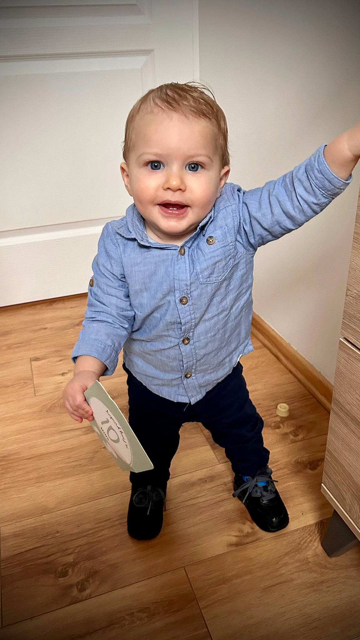Livio a rejoint le concours — aidez-le/la à gagner de superbes lots ! baby_toddler_clothing, cheek, dress_shirt, face, finger, flash_photography, floor, flooring, gesture, happy, hardwood, human_body, person, sleeve, smile, sneakers, sock, standing, t_shirt, toddler