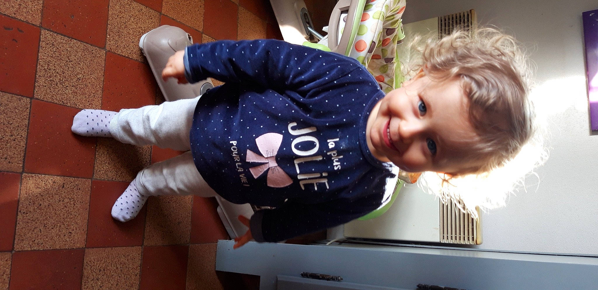 Lina participe au concours pour gagner de l'argent avec cette photo : baby, baby_toddler_clothing, carmine, child, comfort, flooring, fun, happy, joy, knee, person, room, sitting, sleeve, smile, t_shirt, toddler