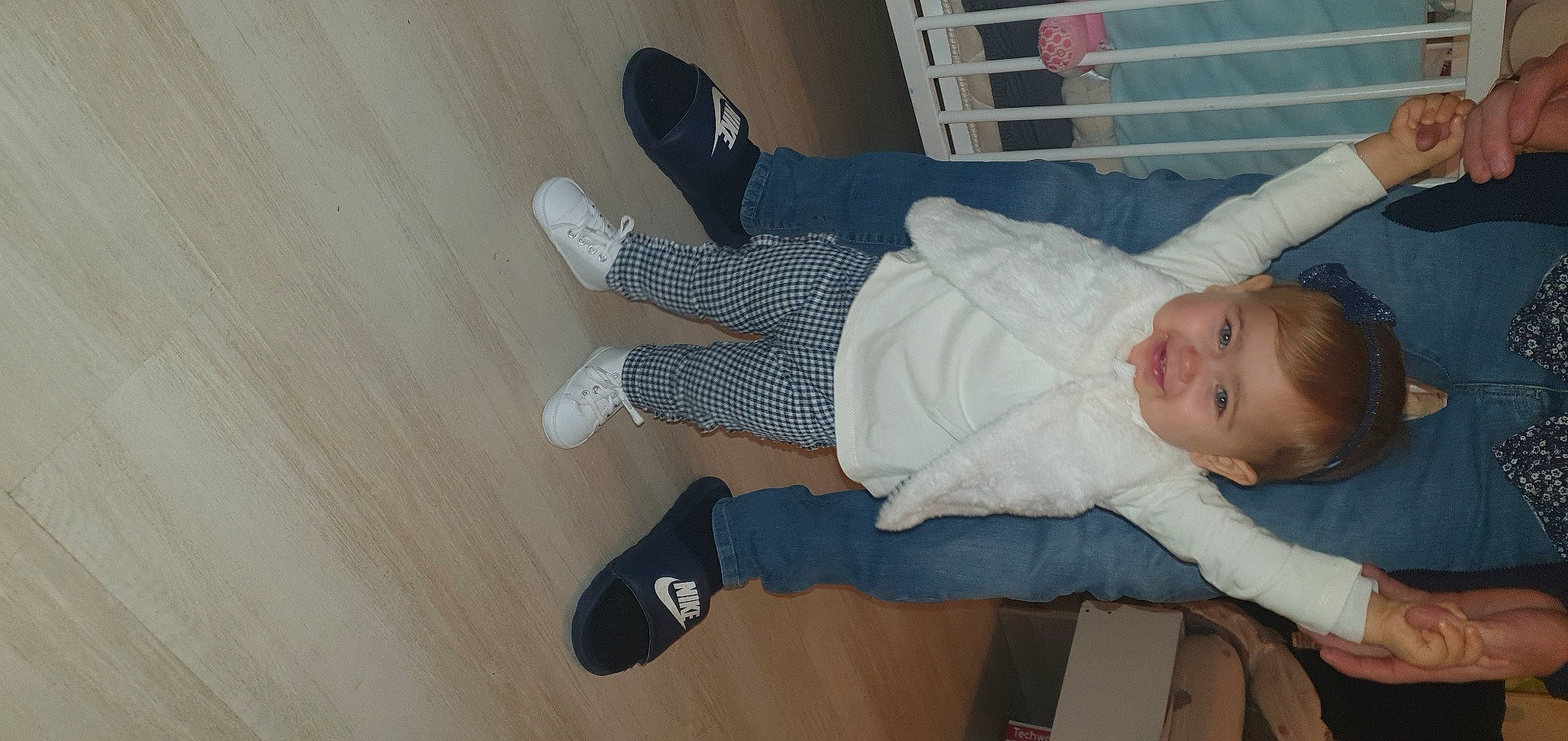 Lyna a rejoint le concours — aidez-le/la à gagner de superbes lots ! baby, baby_toddler_clothing, child, comfort, finger, floor, flooring, fun, hardwood, joy, knee, leg, person, shoe, sitting, smile, sneakers, sock, thumb, toddler