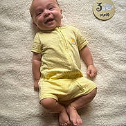 Maëlio participe au concours pour gagner de l'argent avec cette photo : baby, infant, smiling, yellow_clothing, onesie, lying_down, blanket, soft_texture, wooden_plaque, koala, age_marker, happy, cute, portrait, skin, feet, arms, head, child, indoors