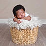 Noah is registered to the contest to win money with this photo: baby, sleeping, basket, fluffy_cushion, curly_hair, indoor, flooring, peaceful, infant, resting, cute, cozy, child, portrait, wood_floor, woven_basket, soft_texture, relaxation, sleep, young_child