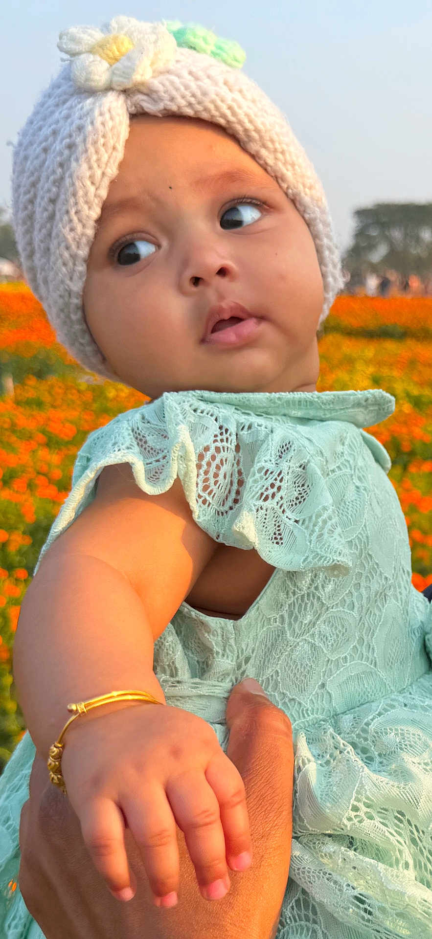 Aliya joined the competition — help win amazing prizes! baby, child, knitted_hat, flower, bracelet, hand, dress, lace, outdoor, field, flowers, nature, person, skin, face, cute, infant, holding, sunlight, expression