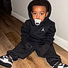 Amir joined the competition — help win amazing prizes! toddler, child, pacifier, hoodie, gloves, sneakers, floor, wood_floor, indoors, young_child, black_clothing, sitting, person, cute, fashion, casual, portrait, expression, baby, home