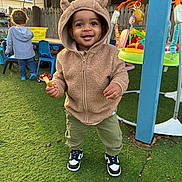 Amir joined the competition — help win amazing prizes! toddler, child, hoodie, bear_ears, sneakers, snack, playground, toys, grass, outdoor, smile, happy, person, baby, casual_clothing, daylight, playtime, fence, background_child, greenery