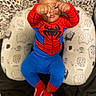 Amir is registered to the contest to win money with this photo: toddler, child, costume, spiderman, red, blue, shoes, sitting, cushion, elephant_pattern, leopard_print, background, fists, pose, indoor, clothing, footwear, cute, playful, person