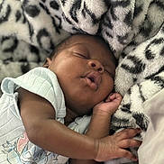 Wisdom joined the competition — help win amazing prizes! baby, sleeping, blanket, onesie, cartoon_character, infant, peaceful, soft_texture, close_up, cute, resting, child, portrait, hand, skin, cozy, indoor, comfort, newborn, relaxation