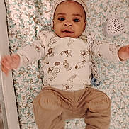 Jahmir joined the competition — help win amazing prizes! baby, infant, child, blanket, hat, clothing, lying_down, cute, happy, smiling, indoors, soft_texture, toy, playful, person, portrait, warm_colors, cozy, toddler, baby_girl_or_boy