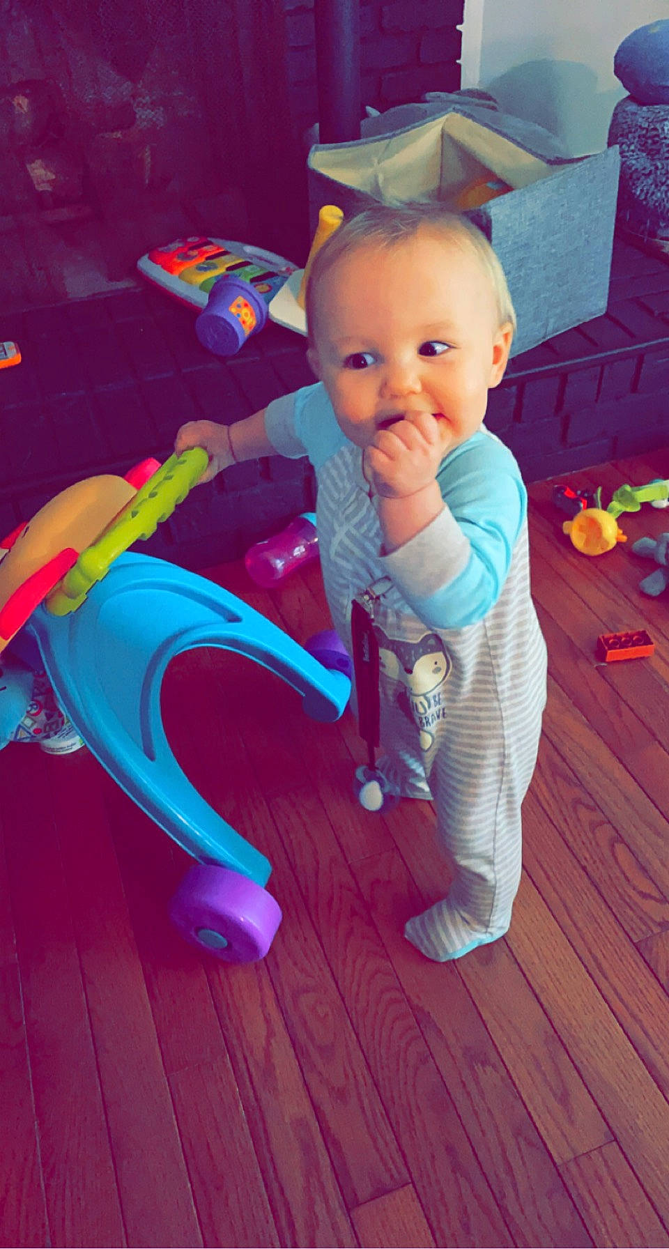 Keenan is registered to the contest to win money with this photo: baby, baby_products, baby_toddler_clothing, baby_toys, child, electric_blue, flooring, fun, happy, hardwood, magenta, person, pink, plastic, play, purple, riding_toy, sitting, toddler, toy