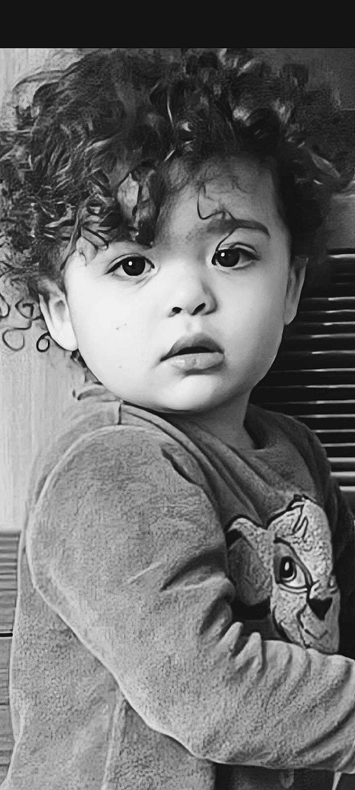 Adam participe au concours pour gagner de l'argent avec cette photo : child, toddler, curly_hair, black_and_white, portrait, close_up, expressive_eyes, long_sleeve_shirt, cartoon_character, indoor, texture, young_child, face, looking_away, cute, innocent, soft_lighting, casual_clothing, person, monochrome