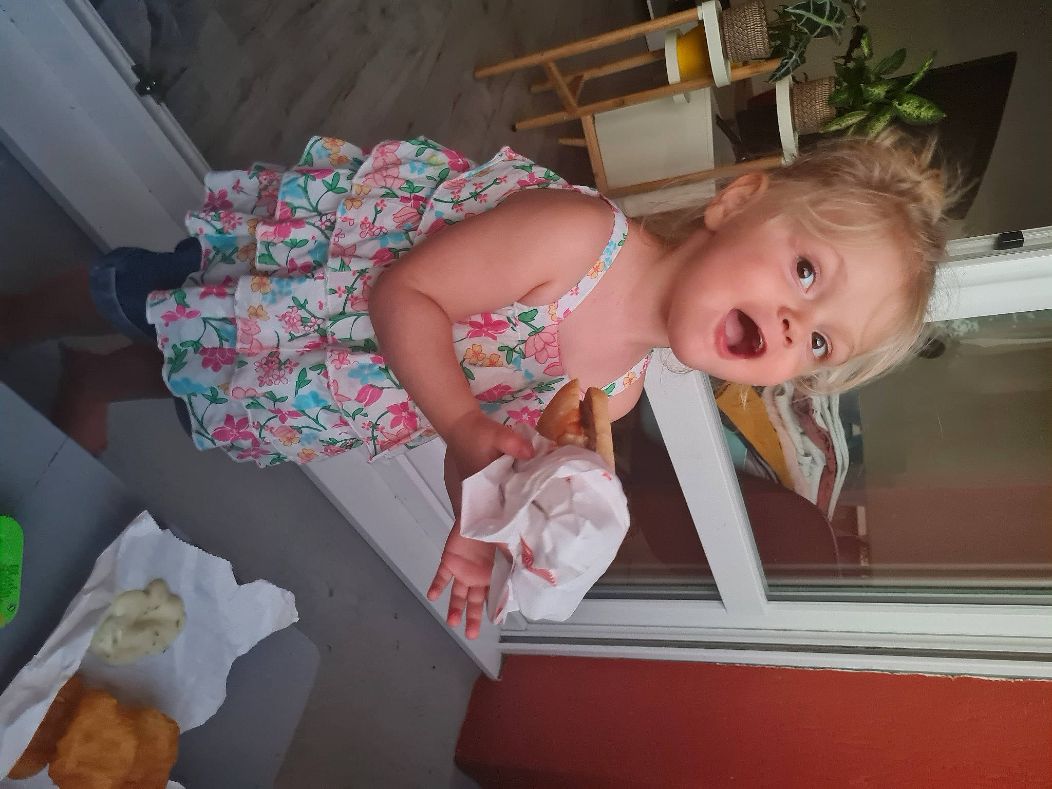 Lilie participe au concours pour gagner de l'argent avec cette photo : baby, baby_products, baby_toddler_clothing, child, comfort_food, cuisine, dress, finger_food, flooring, flowerpot, fun, houseplant, person, pink, plant, room, smile, surprise, toddler, wood