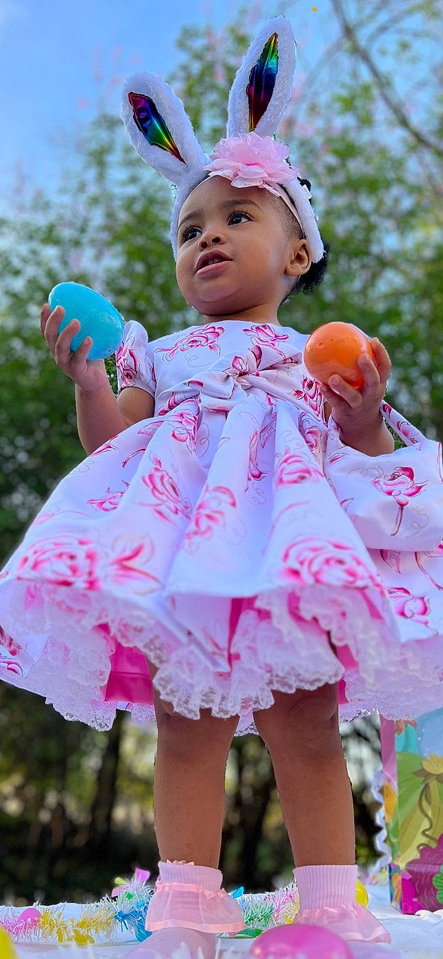 Sarai is registered to the contest to win money with this photo: baby_toddler_clothing, blue, dress, face, finger, fun, grass, green, hand, happy, hat, human_body, leisure, people_in_nature, person, pink, plant, skin, summer, toddler