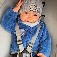 Naël Herrmann a rejoint le concours — aidez-le/la à gagner de superbes lots ! baby, child, blue_jacket, knit_hat, car_seat, smiling, waving_hand, cute, cozy_clothing, safety_harness, grey_hat, infant, portrait, indoor, warm_clothing, toddler, happy, seatbelt, casual, small_hand