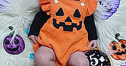 Aurora joined the competition — help win amazing prizes! baby, infant, child, halloween, pumpkin_costume, orange_outfit, bow_headband, jack_o_lanterns, face, portrait, lying_down, smiling, wide_eyed, furry_blanket, milestone_photo, five_months, autumn, festive, indoor, cute
