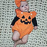 Aurora joined the competition — help win amazing prizes! baby, infant, child, pumpkin_costume, halloween, orange, bow, onesie, black_shirt, blanket, knitted_blanket, lying_down, portrait, indoor, cute, wide_eyed, face, costume, seasonal, photography
