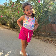 Jade a rejoint le concours — aidez-le/la à gagner de superbes lots ! child, girl, smiling, outdoor, summer, colorful_clothing, shorts, sneakers, posing, nature, plants, flowers, sunlight, pathway, happy, casual, daytime, portrait, fashion, playful