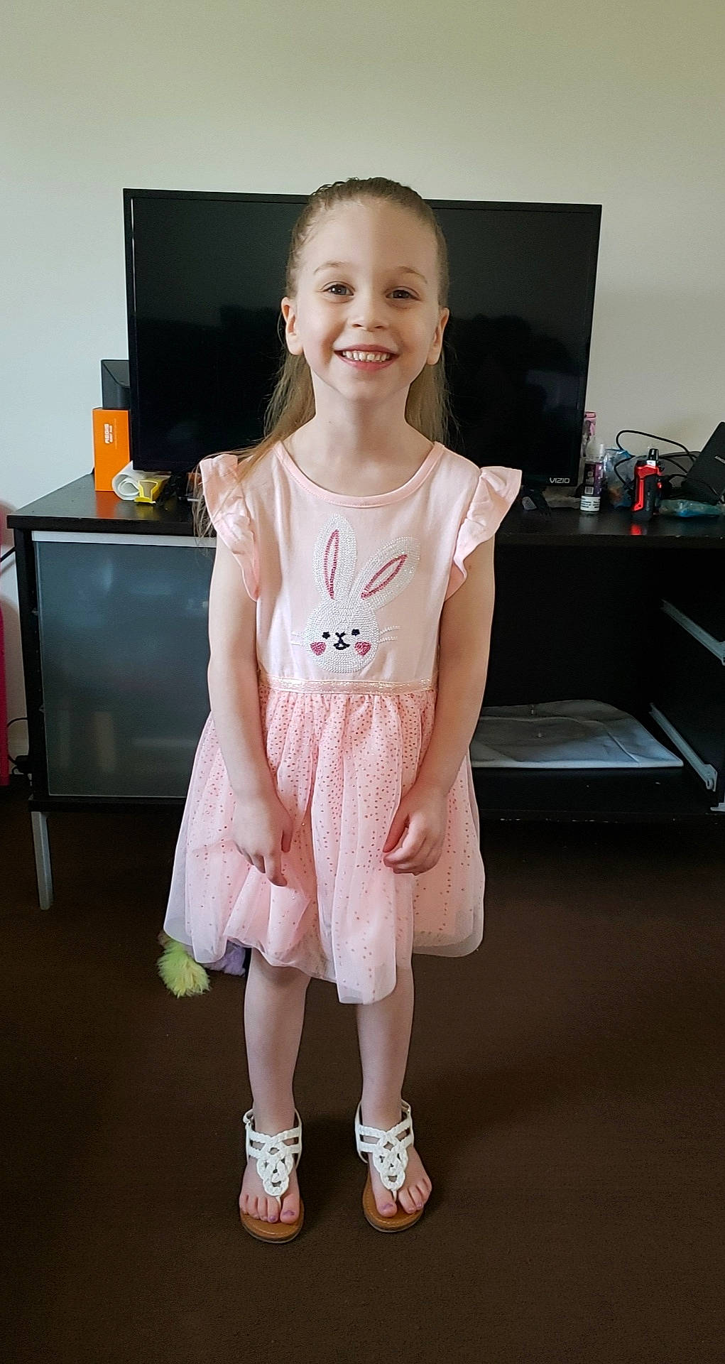 Leila is registered to the contest to win money with this photo: baby_toddler_clothing, dress, face, floor, flooring, hand, happy, human_body, joint, joy, knee, neck, person, pink, shoulder, skin, sleeve, smile, standing, t_shirt