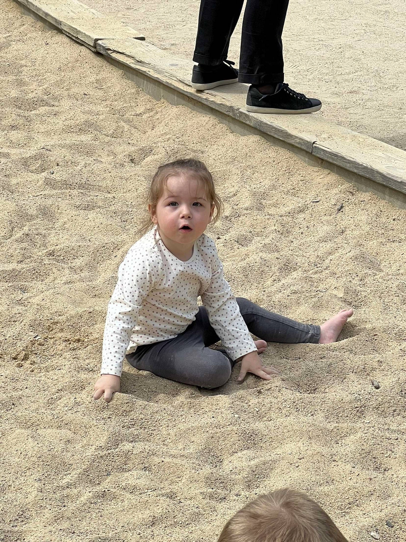 Léna participe au concours pour gagner de l'argent avec cette photo : asphalt, black, floor, flooring, fun, grass, happy, human_leg, leg, leisure, people_in_nature, person, photograph, road_surface, sidewalk, snapshot, standing, toddler, trousers, white