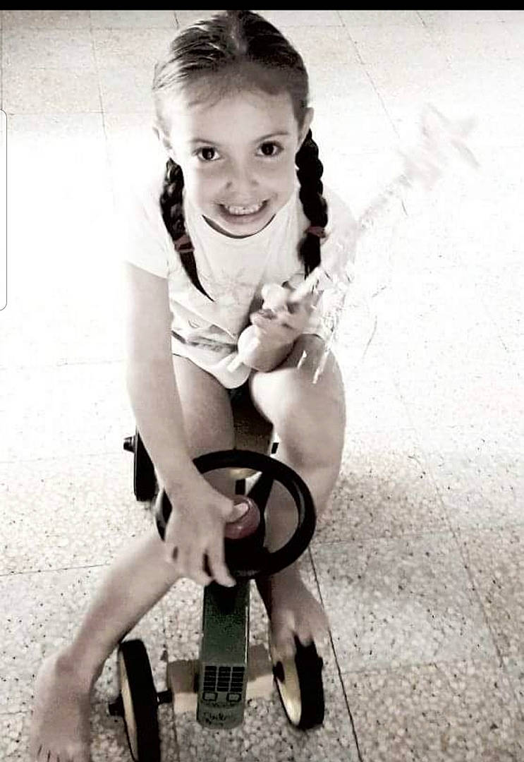 Raphaëlle participe au concours pour gagner de l'argent avec cette photo : arm, child, elbow, eye, flash_photography, fun, gesture, happy, human_leg, joy, knee, monochrome, monochrome_photography, person, sandal, sitting, smile, style, thigh, tire