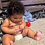 baby, bed, blanket, casual, child, curly_hair, cute, diaper, focus, foot, hand, home, indoor, infant, person, playing, red_ball, skin, toy, wooden_headboard
