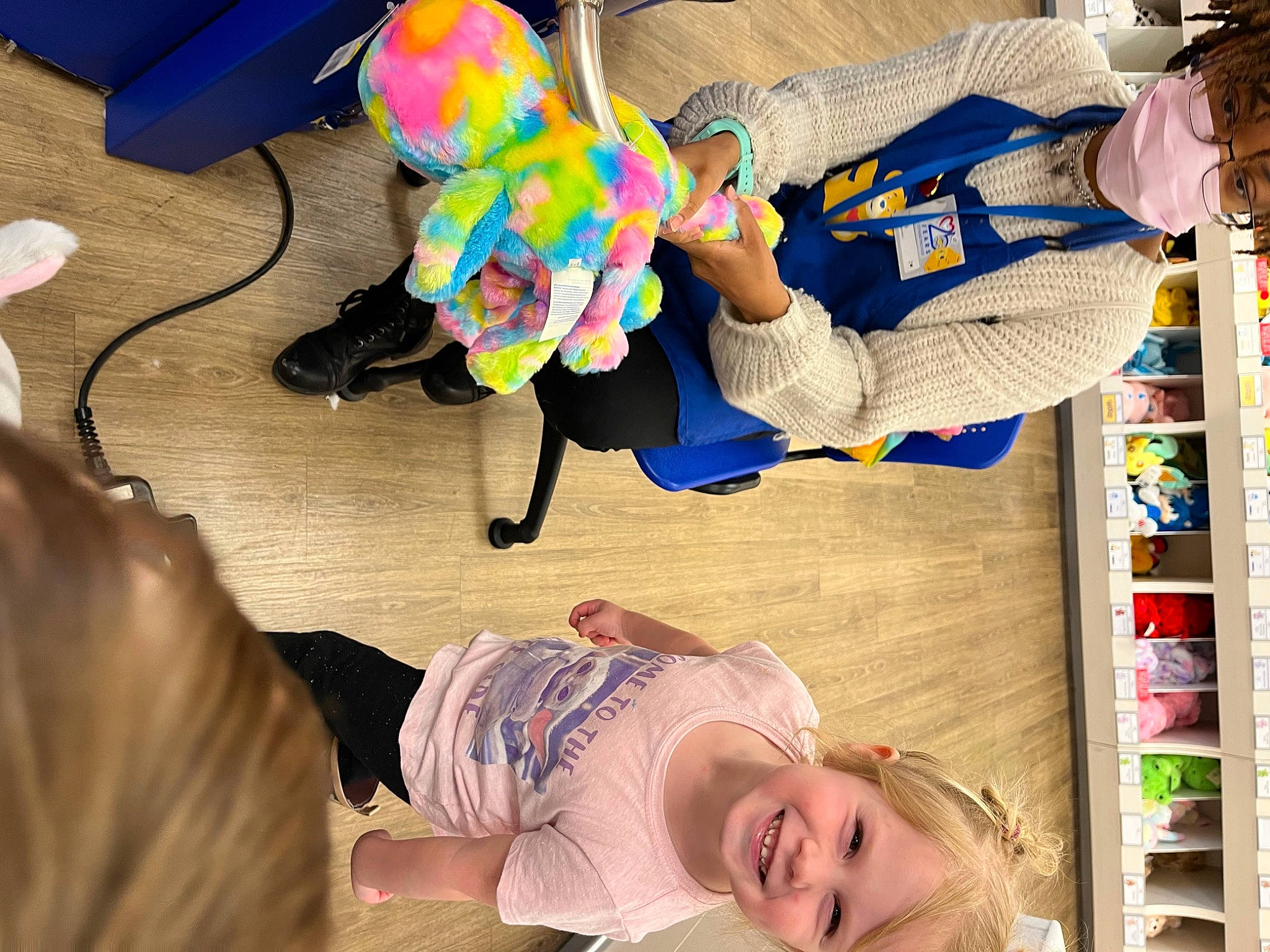 Kennedi is registered to the contest to win money with this photo: child, flooring, fun, happy, human_leg, joy, knee, leisure, person, play, room, shoe, sitting, smile, sneakers, sportswear, stuffed_toy, t_shirt, thigh, toddler