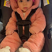 Camila is registered to the contest to win money with this photo: baby, infant, car_seat, pink_onesie, hat, boots, child, cute, fluffy_clothing, safety_harness, indoor, portrait, young_child, wide_eyes, adorable, warm_clothing, seated, expression, person, winter_wear