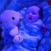 Aurora joined the competition — help win amazing prizes! baby, blanket, plush_toy, octopus, pacifier, cushion, elephant_pattern, soft_toy, child, indoors, blue_light, smiling, wrapped, cute, infant, sleeping_area, comfort, person, baby_accessory, resting